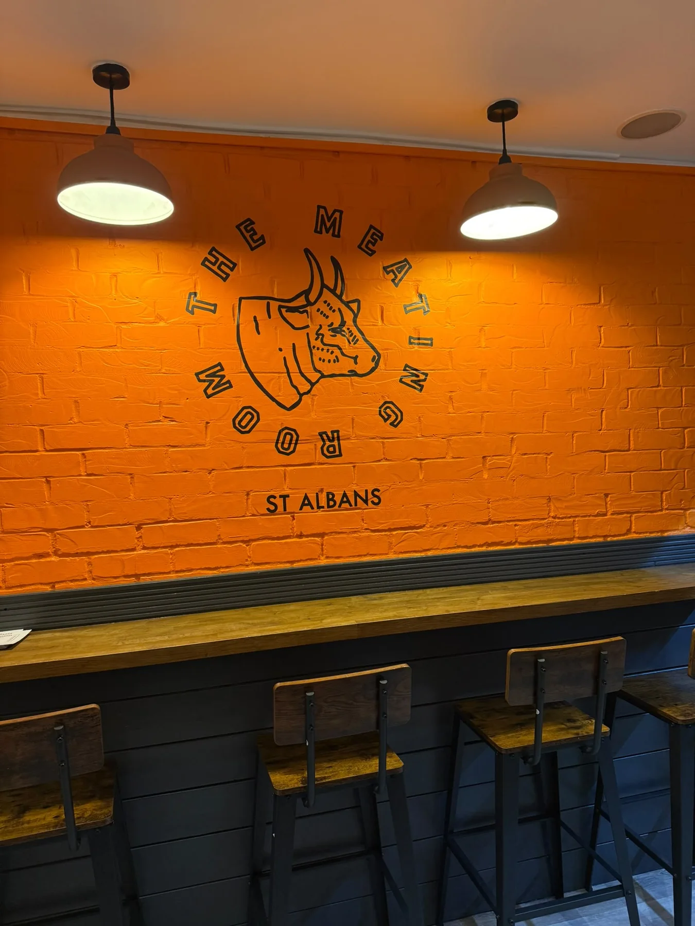 The Meating Room orange brick wall with local St Albans branding